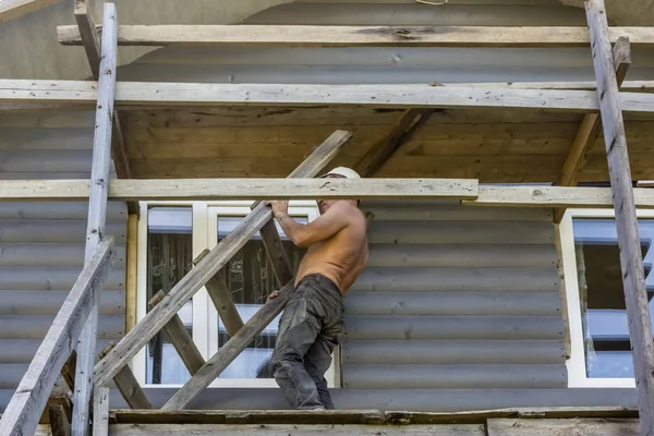 Mannelijke Bouwer Trekt Een Ladder Bouwplaats Van Houten Huis — Stockfoto