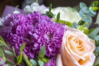 Gül, aster ve diğer bitkilerden bir buket çiçek.