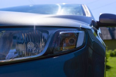 Açık, güneşli bir günde arabanın farları kapalı.