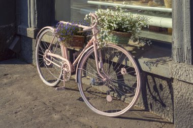 Şehrin sokaklarında çiçek sepetleriyle retro tarzı bisiklet.