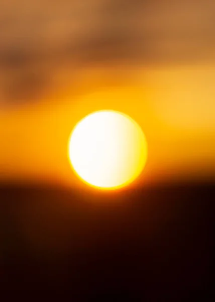 Natural sun background of bright white hot solar ball at sunset