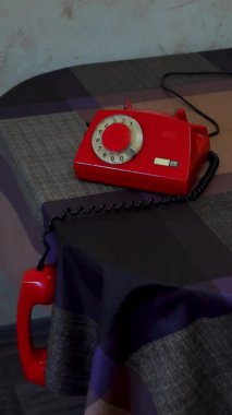 Masadan sarkan, dikey, eski bir döner telefon ahizesi.