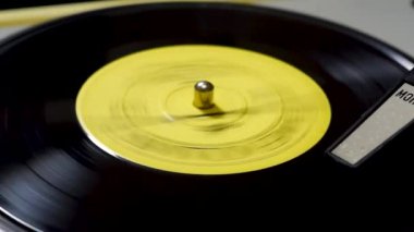 Retro müzik plağı eski pikapta yakın planda çalıyor.