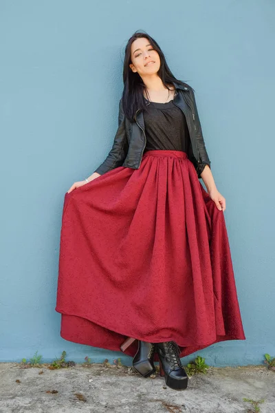 Siyah deri ceket ve mavi bir duvarın önünde dans koyu kırmızı elbise giymiş karışık yarış erkek