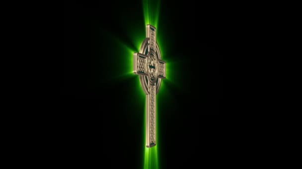 Celtic Gold Cross with green glowing rays rotates around an axis on a black background. Seamless looping — Stock Video