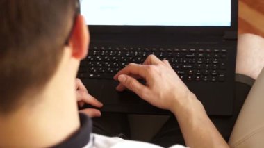 Bir adam bir dizüstü bilgisayarda çalışır ve fare touchpad taşır