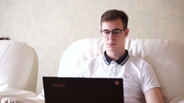 Jonge man kijkend naar zijn laptop — Stockvideo