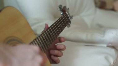 Bir adam gitar dizeleri ayarlar