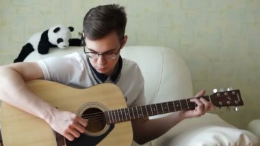 Bir adam ahşap bir gitar çalar