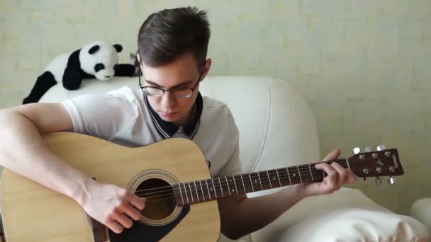 Un hombre toca una guitarra de madera — Vídeos de Stock