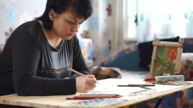 Sanatçı bir resim tablosuna çizilir.