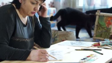 Bir kadın çizer ve telefonda konuşuyor