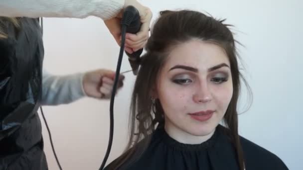 The girl smiles at the camera during the hairstyle — Stock Video