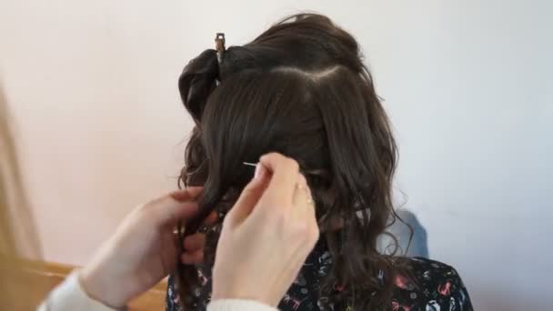 Стилист кладет прядь волос — стоковое видео