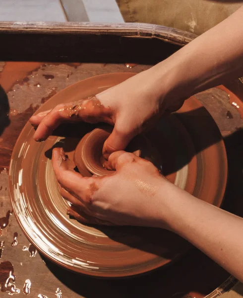 Making dirty hands of raw clay ware in a pottery workshop