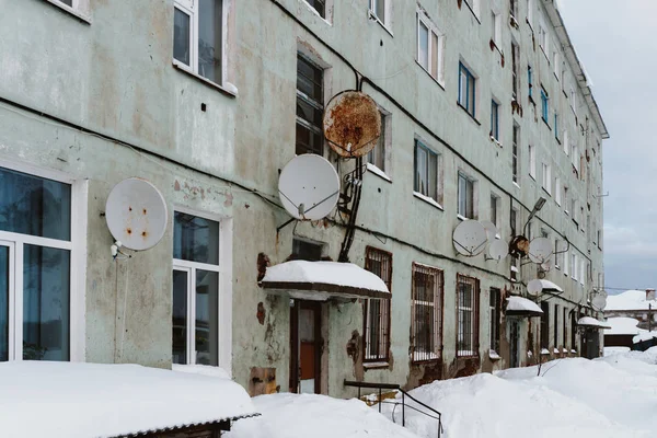 Eski harap ve kısmen tahrip içinde insanlar hala Kuzey köyünde kış beyaz kar kalın çamur altında canlı evleri