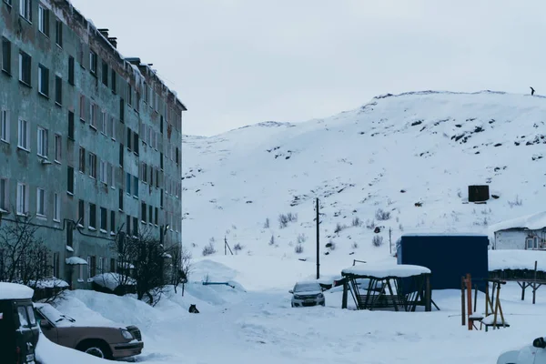 Eski harap ve kısmen tahrip içinde insanlar hala Kuzey köyünde kış beyaz kar kalın çamur altında canlı evleri