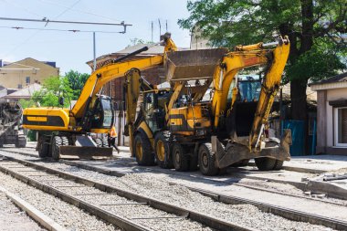 Büyük bir şehirde bir sokak yeniden inşası üzerinde güçlü sarı Ekskavatör