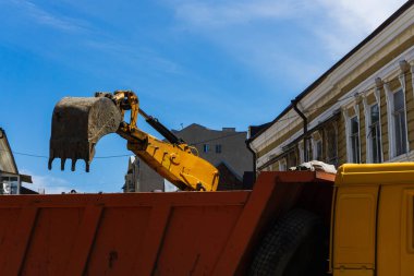 Büyük bir şehirde bir sokak yeniden inşası üzerinde güçlü sarı Ekskavatör