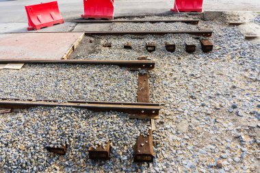 Ahşap uyuyanlar büyük ezilmiş taş şehir merkezinde yeni tramvay hatları için hazırlanmış bir höyük üzerinde yeni çelik rayların döşenmesi