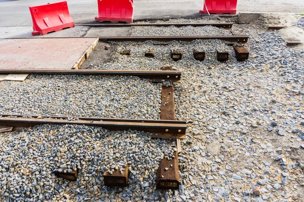 Ahşap uyuyanlar büyük ezilmiş taş şehir merkezinde yeni tramvay hatları için hazırlanmış bir höyük üzerinde yeni çelik rayların döşenmesi