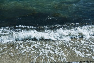 Küçük dalgalar deniz tatil sahilde karanlık deniz kıyısında akşam başlayan fırtına esnasında köpük ile