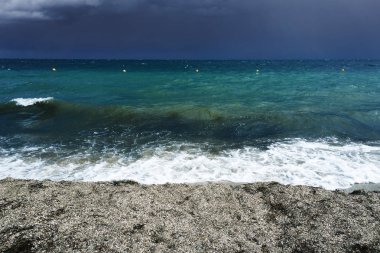 Küçük dalgalar deniz tatil sahilde karanlık deniz kıyısında akşam başlayan fırtına esnasında köpük ile