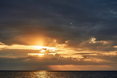 Ufuk çizgisi deniz ve su yüzeyine son ışınları yansıması ötesinde güzel parlak turuncu günbatımı