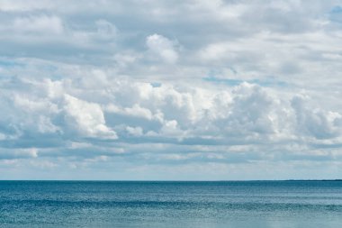 Sakin bir mavi deniz üzerinde büyük kara bulutlar güneşin sıcak yaz gününde kapak.