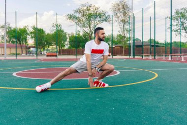 Beyaz gömlekli sakallı genç bir adam spor ve ücretsiz spor zemin üzerinde moussy egzersizleri yapıyor büyük bir şehirde