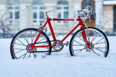 Metalden yapılmış bir kırmızı bisiklet bir oyuncak model iyi doğruluk ile yürütülen, kış snowdrifts ve soğuk hava bir şehir sokak üzerinde mevcuttur