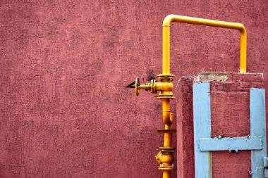 sokakta bir yaz gününde bina eski sarı gaz borusu evlere bir taş duvar ev gaz temini için yuvarlak bir musluk ile renkli