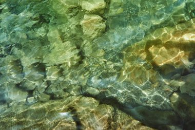 bir taş ocağı dik kayalık sahilleri ve sıcak bir yaz gününde büyük kayalar grubu olmadan vahşi bir göl kıyısında, berrak mavi soğuk su