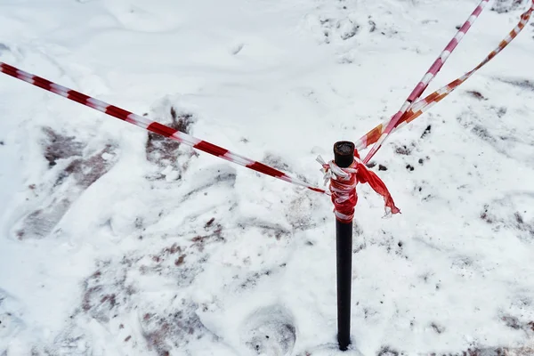 Fencing tape warns of the danger of icicles in winter in winter along the house