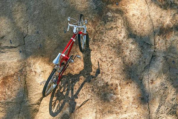 red metal toy bike on the lake with clear water on a clear sunny day in summer while traveling