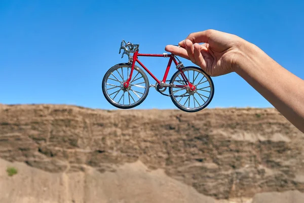 Bicicleta Juguete Metal Rojo Las Manos Contra Fondo Acantilado Distancia — Foto de Stock