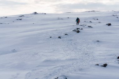 bir grup insan ağır kış boyunca kutup tundra gezisi sebebiyle karla kaplı bir tepe izleyin