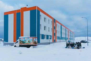 Teriberka, Murmansk bölgesi / Rusya - Şubat 2018: yeni konut 3 katlı ev ile kaplı renkli bir kış soğuk günde kutup kuzey kutup dairesi ötesinde bir köyde siding