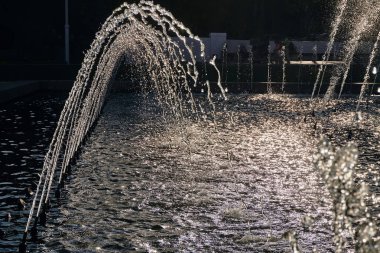 su jetleri, ışınları hava güneşli yaz gününde şehrin merkezi şehir parkta bir büyük çeşme Parlatıcı