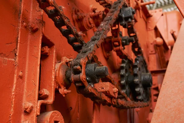 High-quality metal gears and chains on an old tractor of bright orange color in the museum of agricultural equipment — Stock Photo, Image