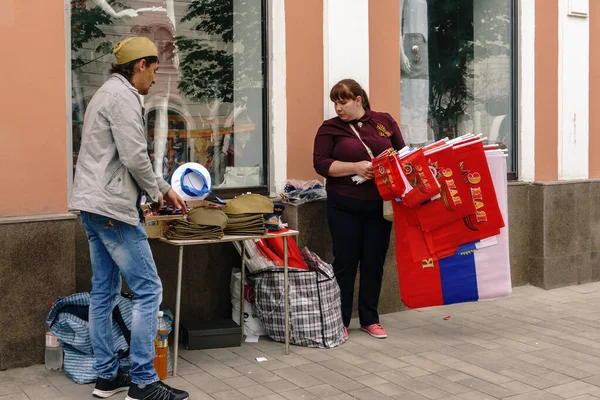 Rostov-on-Don / Rússia - 9 de maio de 2018: vendedores de rua nas mesas no meio da rua vendem lembranças, bandeiras vermelhas, fitas de São Jorge e simbolismo militar em homenagem ao feriado do Dia da Vitória — Fotografia de Stock