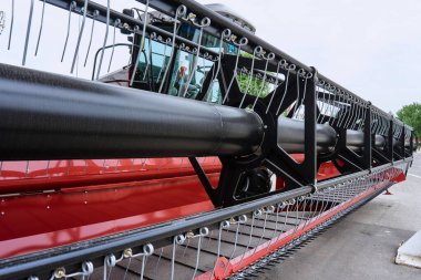 Yüklü aygıtları tarım alanları işlemek için yeni bir birleştirme bir büyük makine bitki kırmızı ve beyaz renklerin üzerinde