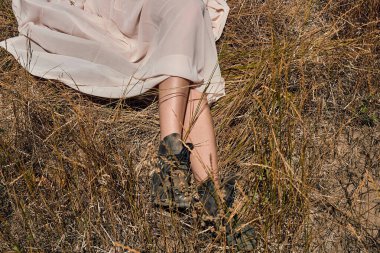 bir ışık Yaz elbiseli bir kız sıcak güneşli bir günde bacaklarını yayılan altın bir alanda yalan söylüyor