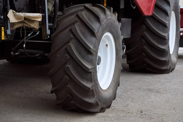 Stora däck med en stor trampa på en ny jordbruks traktor efter montering på plant på en solig dag — Stockfoto