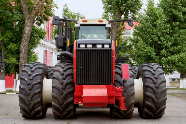 Baksidan av en stor traktor för jordbruk nymalen picklad röd i en stor anläggning efter montering på en sommardag — Stockfoto