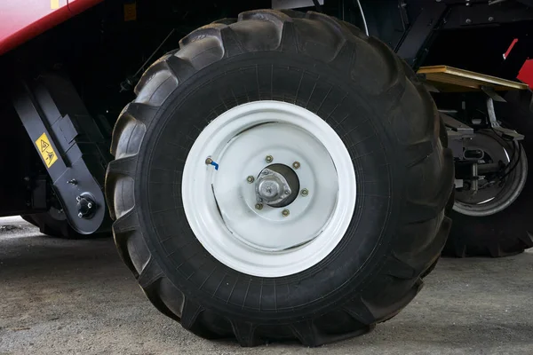 Neumáticos grandes con una gran banda de rodadura en un nuevo tractor agrícola después del montaje en la planta en un día soleado —  Fotos de Stock