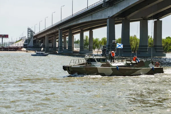 Rostov-on-Don / Russia - May 2018: a river parade of warships in honor of the holiday near the city embankment pass under the new automobile bridge over the Don on a clear warm day — Stock Photo, Image