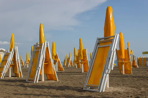 Sillas de playa y sombrillas en la playa vacía después de la lluvia —  Fotos de Stock