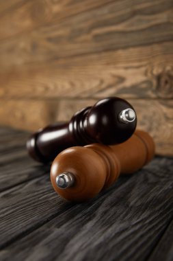 wooden pepper grinder and salt grinder on wooden floor clipart