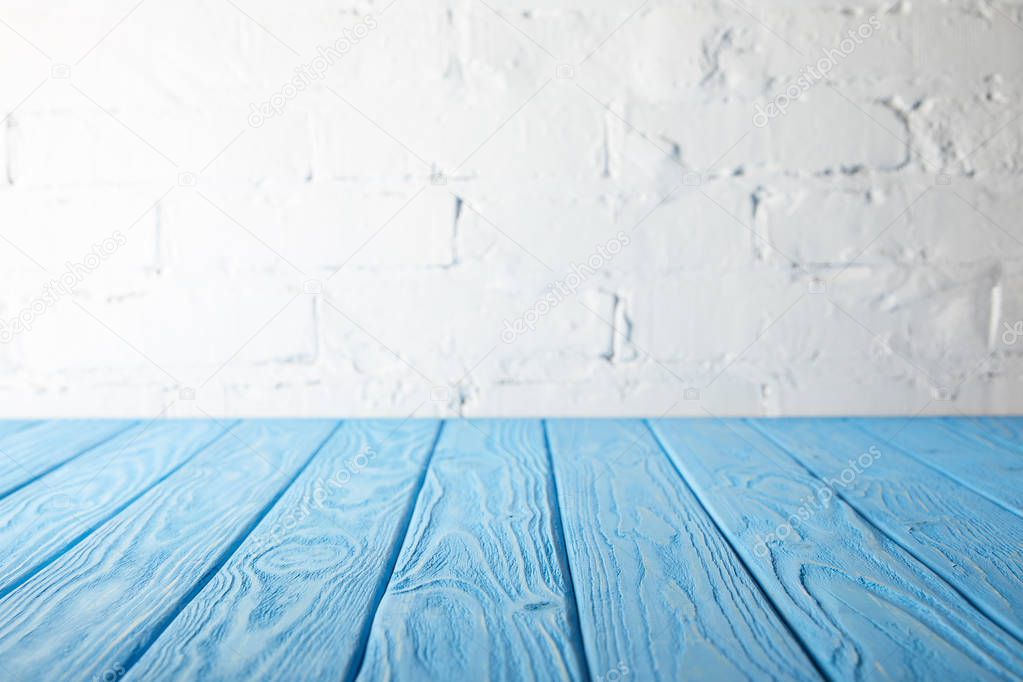 light blue wooden tabletop and white wall with bricks